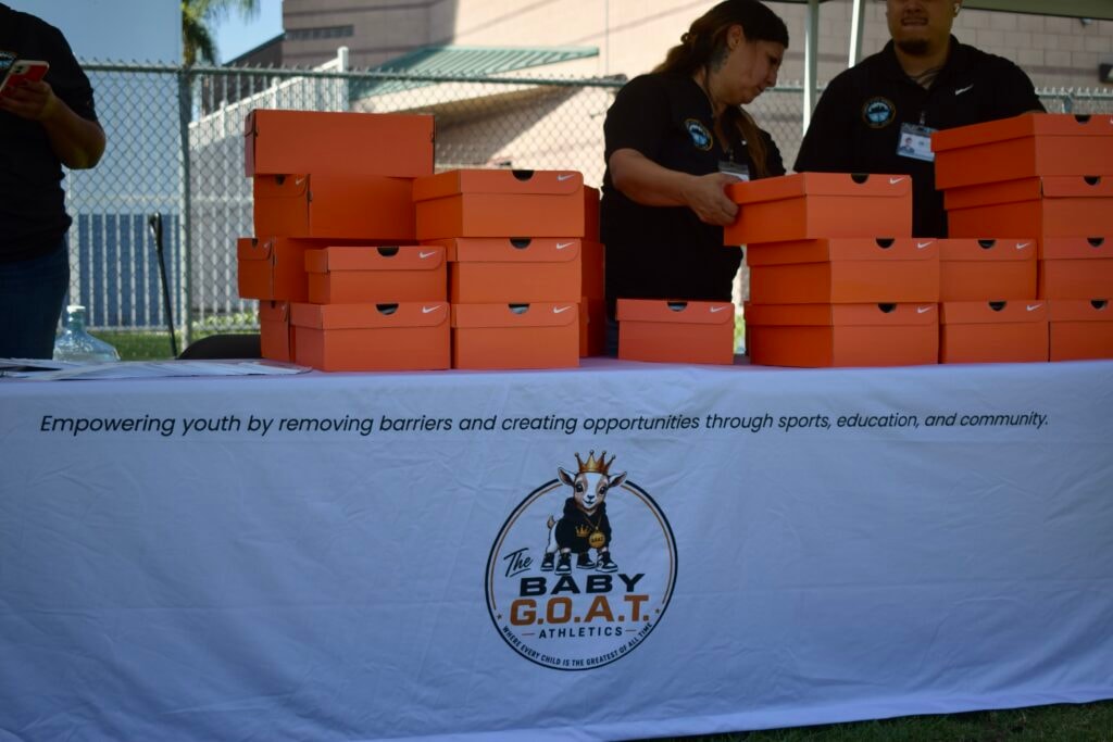 Baby G.O.A.T. Athletics Football Cleats Scholarship Giveaway — stacks of Nike shoe boxes ready for youth recipients